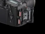 Close-up of a DSLR camera with dual SanDisk memory cards inserted.