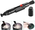 Camera lens cleaning pen with brush and cap for photography equipment maintenance.