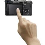 Person using touchscreen on Sony mirrorless camera, available at Camix UK.