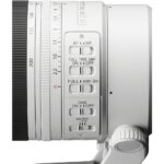 Close-up of a white camera lens with focus and mode switches, ideal for professional photography.