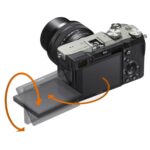 Sony A7C camera with 28-60mm lens, silver, rear view showing tilting screen.