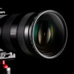 Close-up of a Sony camera lens on a tripod, ideal for professional photography.