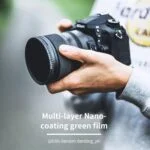 Person holding a DSLR camera with a lens, showcasing multi-layer nano-coating green film.