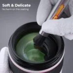 Cleaning a camera lens with a soft brush, safe for lens coating.