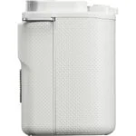 Side view of a white compact digital camera body with textured grip.