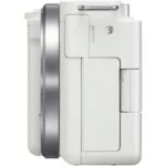 Side view of a white compact digital camera body with lens mount.
