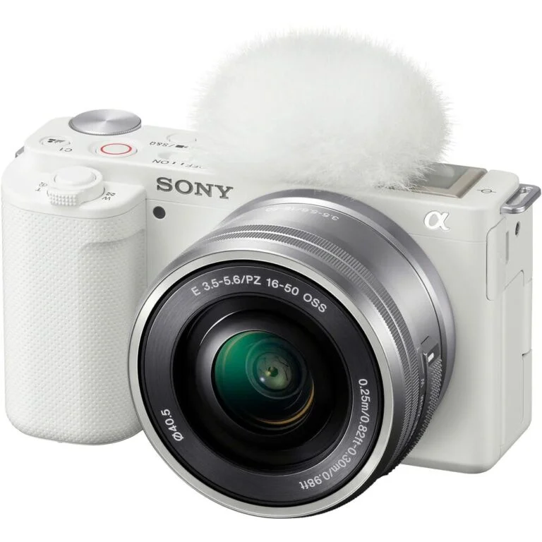 White Sony mirrorless camera with lens and microphone, ideal for photography and video.