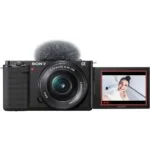 Sony mirrorless camera with flip-out screen displaying a smiling person, ideal for vlogging and photography.