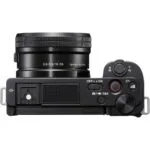 Top view of a mirrorless camera with a 16-50mm lens, featuring control dials and buttons.