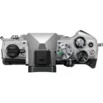 Top view of a silver mirrorless camera body with control dials and buttons.