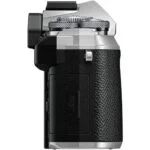 Side view of a silver and black mirrorless camera body with textured grip.