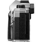 Side view of a silver and black mirrorless camera body with textured grip.