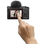 Person using a digital camera with touchscreen, ideal for vlogging and photography.