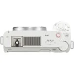 Top view of a white mirrorless camera with control dials and hot shoe, ideal for photography enthusiasts.
