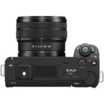 Top view of a Sony mirrorless camera with lens, featuring control dials and buttons.