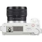 Top view of a white Sony mirrorless camera with lens, featuring control dials and buttons.