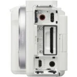 White mirrorless camera body with open ports and card slots, ideal for photography enthusiasts.