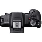 Top view of Canon EOS R100 camera body with control dials and hot shoe.