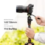 Person adjusting camera on tripod, showcasing photography gear.