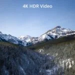 Snow-covered mountains under clear sky, showcasing 4K HDR video quality.