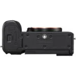 Bottom view of a mirrorless camera body, showcasing battery compartment and tripod mount.