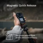 Person holding a camera with magnetic quick release feature outdoors.