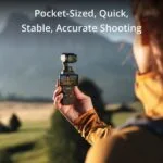 Person using a compact camera gimbal outdoors for stable shooting.