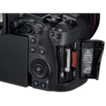 Close-up of a digital camera with open memory card slot, showcasing photography equipment.