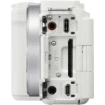 Side view of a white mirrorless camera body with various ports and slots.