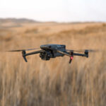 DJI drone flying over a field, showcasing advanced photography equipment.