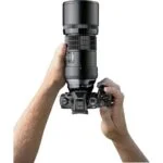 Hands holding a professional camera with a large lens, ideal for photography enthusiasts.