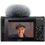 Sony digital camera with flip screen displaying a smiling person, ideal for vlogging and photography.