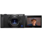 Sony digital camera with flip-out screen displaying a person, ideal for vlogging and photography.