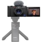 Sony digital camera with flip screen and tripod, ideal for vlogging and photography.