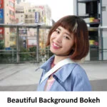 Smiling person with cityscape background, showcasing bokeh effect.