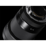 Close-up of a Sigma camera lens on a black background.