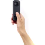 Hand holding a compact digital camera, ideal for photography enthusiasts.