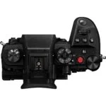 Top view of a Panasonic mirrorless camera body with control dials and buttons.
