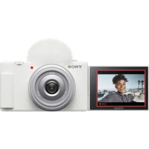 Sony digital camera with flip-out screen displaying a smiling person, ideal for vlogging and photography.