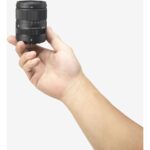 Hand holding a Sigma camera lens, ideal for photography enthusiasts.