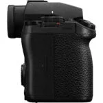 Side view of a black camera body with textured grip and control dials.