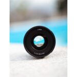 Lumix camera lens on a textured surface, ideal for photography enthusiasts.