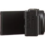 Side view of a compact digital camera with a flip-out screen.