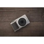 Compact digital camera on wooden surface, ideal for photography enthusiasts in the UK.