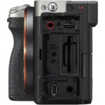 Side view of a mirrorless camera body with open ports and card slots.