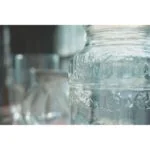 Close-up of decorative glass jars with intricate patterns in soft lighting.