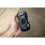 Waterproof Pentax camera held in hand, ideal for outdoor photography.