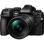 OM System mirrorless camera with lens, available at Camix UK.