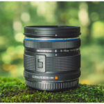 Wide angle camera lens on mossy surface, ideal for landscape photography.