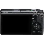 Back view of a Ricoh compact digital camera with LCD screen and control buttons.